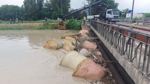 Bad weather.In Modena Secchia in flood, working to avoid the bales (of hay)