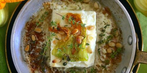 Feta asado con flores de calabacín, miel y piñones.la receta